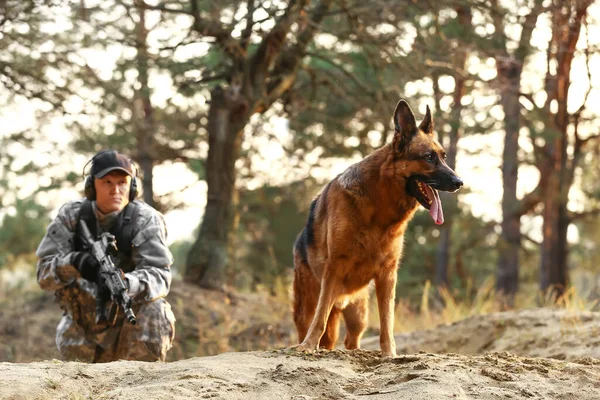 Dışarıdaki savaş sırasında askeriyede çalışan köpeği olan bir asker.