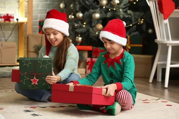 クリスマスの前夜に家で贈り物を持つ幸せな小さな子供たち — ストック写真