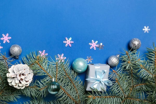 Рождественская композиция с подарочной коробкой, шарами и елками на синем фоне