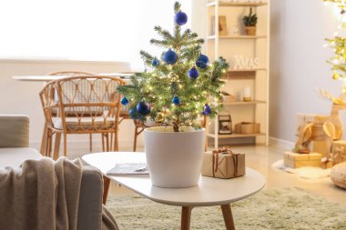 Küçük bir Noel ağacı. Parlayan ışıklar ve odadaki hediyeler.