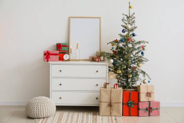 Çekmece sandığında hediyeler ve ışık duvarının yanında Noel ağacı olan boş çerçeve.