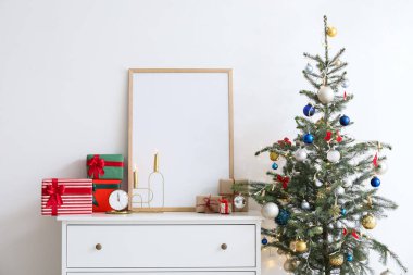 Çekmece sandığında hediyeler ve ışık duvarının yanında Noel ağacı olan boş çerçeve.