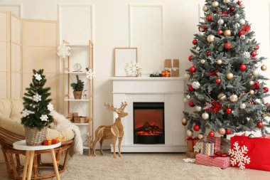 İçinde şömine, Noel ağacı ve katlanan ekran olan aydınlık oturma odası.