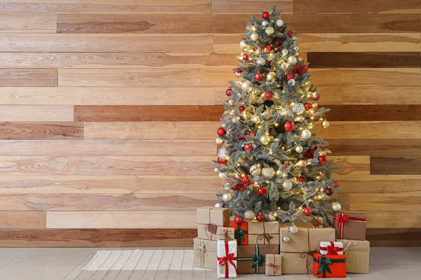 Gyönyörű Karácsonyfa Ragyogó Fények Ajándékok Közelében Fából Készült Fal — Stock Fotó