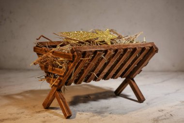 Manger with hay on light background clipart