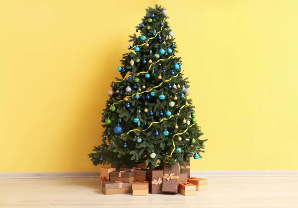 Bela Árvore Natal Com Presentes Perto Parede Amarela — Fotografia de Stock