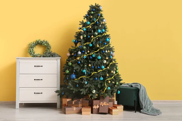 Bela Árvore Natal Com Presentes Cômoda Pufe Perto Parede Amarela — Fotografia de Stock