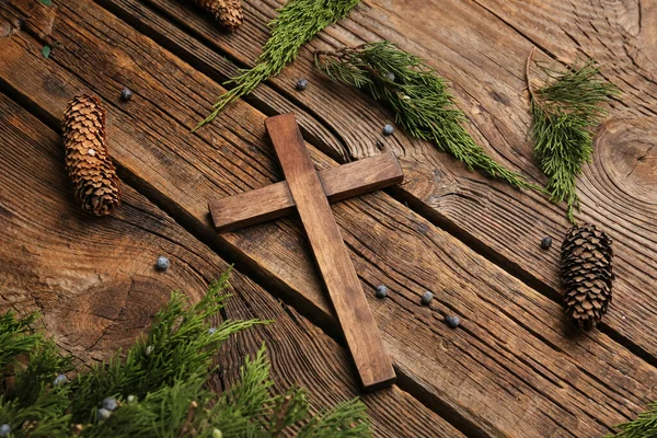 木製の背景に木の枝やコーンとのクロス クリスマスストーリーの概念 — ストック写真