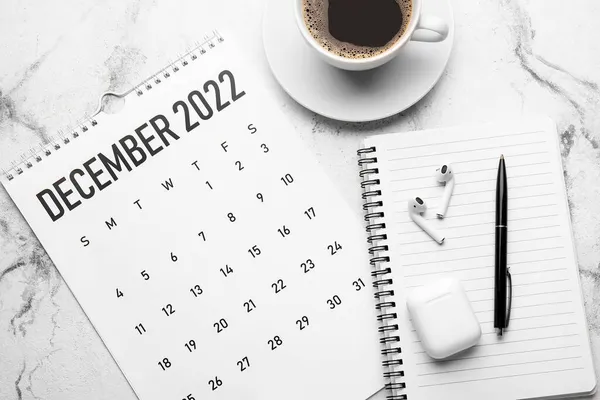 Calendario Papel Para Diciembre 2022 Cuaderno Bolígrafo Auriculares Taza Café —  Fotos de Stock