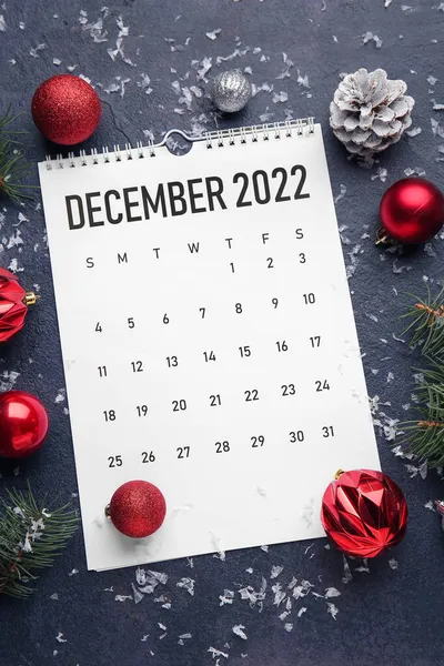 2022年12月的纸质日历和深色背景的圣诞装饰 — 图库照片
