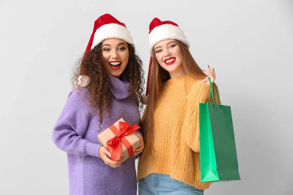 Piękne Młode Kobiety Prezentem Świątecznym Torbą Zakupy Lekkim Tle — Zdjęcie stockowe