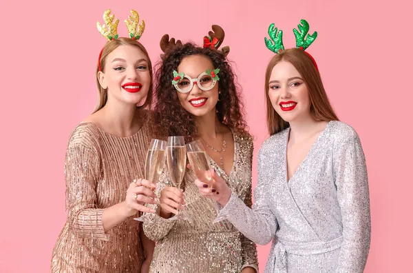 Schöne Junge Frauen Mit Weihnachtsdekor Und Champagnergläsern Auf Farbigem Hintergrund — Stockfoto