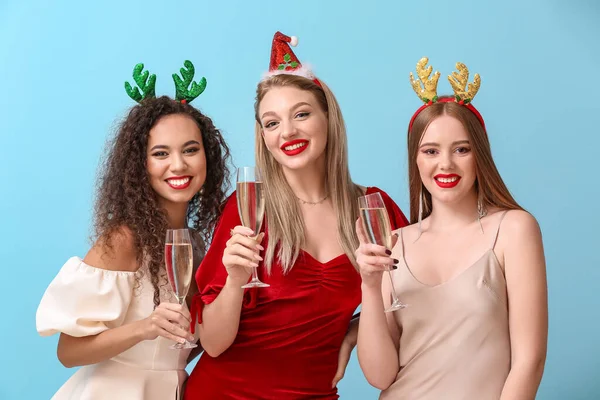 Красивые Молодые Женщины Рождественским Декором Бокалами Шампанского Цветном Фоне — стоковое фото