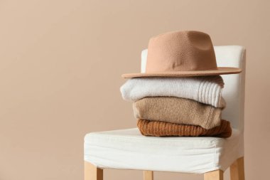 Hafif arka planda sandalyede şık kışlık elbiseler