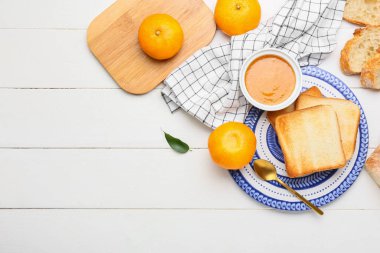 Lezzetli bir kase mandalina reçeli ve hafif ahşap arka planda ekmekli kompozisyon