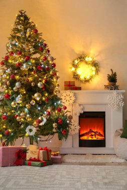 Oturma odasında güzel bir Noel ağacı ve şömine.