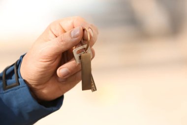 Anahtarı elinde tutan bir adam.