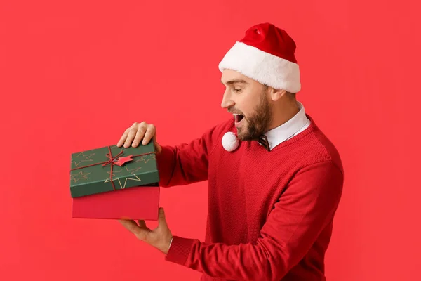 Surpris Jeune Homme Ouvrant Cadeau Noël Sur Fond Couleur — Photo