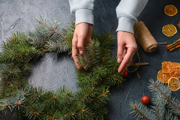 Siyah Arka Planda Köknar Dallarından Noel Çelengi Yapan Kadın — Stok fotoğraf