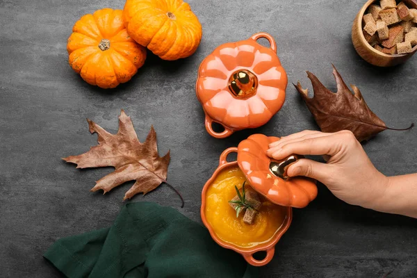 Weibliche Hand Mit Töpfen Leckerer Kürbiscremesuppe Auf Schwarzem Hintergrund — Stockfoto