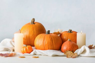 Taze balkabakları ve ışık arka planında mumlar