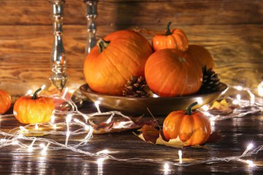 Koyu ahşap arka planda parlayan ışıkları olan taze balkabakları.