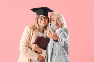 Annesiyle birlikte mutlu bir kız öğrenci. Renkli bir özçekim yapıyor.