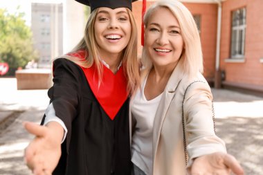 Mezuniyet gününde annesi ile mutlu genç kadın