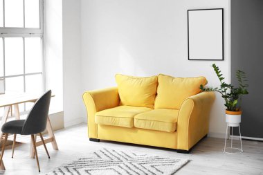 Rahat sarı kanepe ve ışık duvarında asılı boş çerçeve