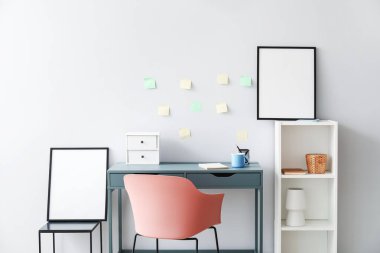 Rafları ve ışık duvarının yanındaki boş çerçeveleri olan modern işyeri