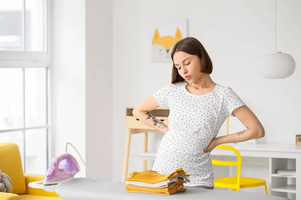 Young Pregnant Woman Tired Ironing Baby Clothes Home — Stock Photo, Image