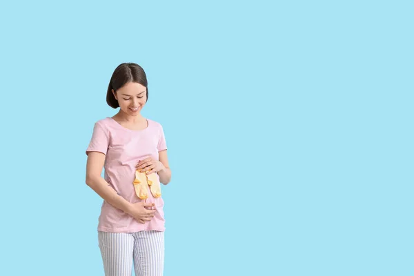 Jeune Femme Enceinte Avec Des Chaussettes Bébé Sur Fond Bleu — Photo