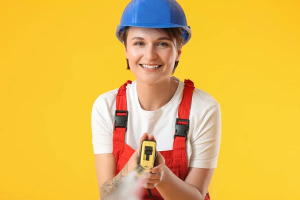 Female Construction Worker Hardhat Measuring Tape Yellow Background — Stock Photo, Image
