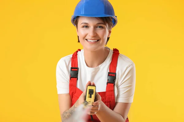 Trabajadora Construcción Hardhat Con Cinta Métrica Sobre Fondo Amarillo — Foto de Stock