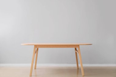 Işık duvarının yanındaki ahşap yemek masası.