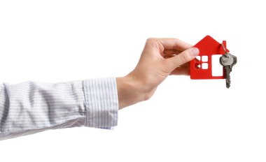 Evin anahtarlarını beyaz arka planda taşıyan genç bir kadın.