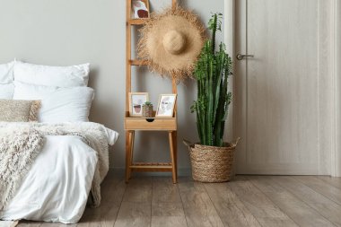 Yeşil kaktüs ve açık renk yatak odalı ahşap masa.