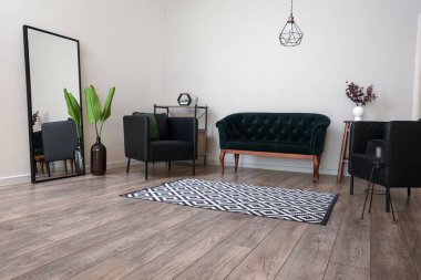 Modern oturma odasının içinde kanepesi olan siyah koltuklar.