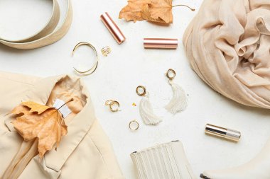 Moda kadın kıyafetleri, aksesuarlar ve arka planda kuru yapraklar