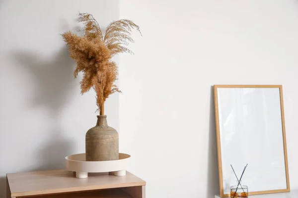 Vas Dengan Alang Alang Kering Atas Meja Dekat Dinding Cahaya — Stok Foto