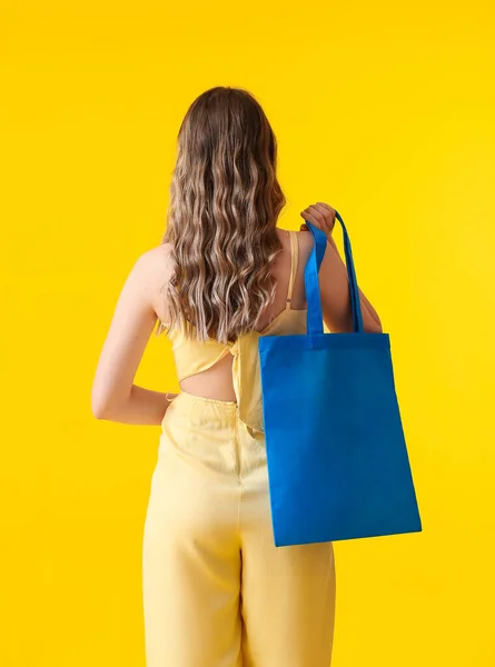 Sarı Arka Planda Mavi Çantalı Genç Bir Kadın — Stok fotoğraf