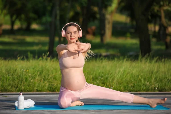 Young Pregnant Woman Headphones Practicing Yoga Park — Stock Photo, Image