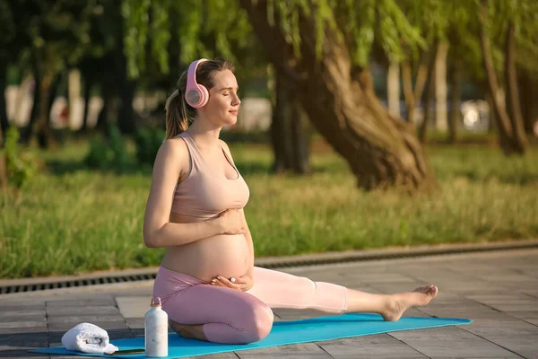 Young Pregnant Woman Headphones Practicing Yoga Park — Stock Photo, Image