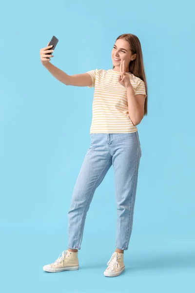 Jolie Femme Avec Téléphone Portable Prenant Selfie Sur Fond Bleu — Photo