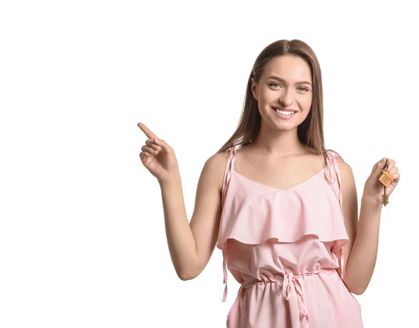 Lächelnde Junge Frau Mit Hausschlüssel Zeigt Auf Etwas Auf Weißem — Stockfoto