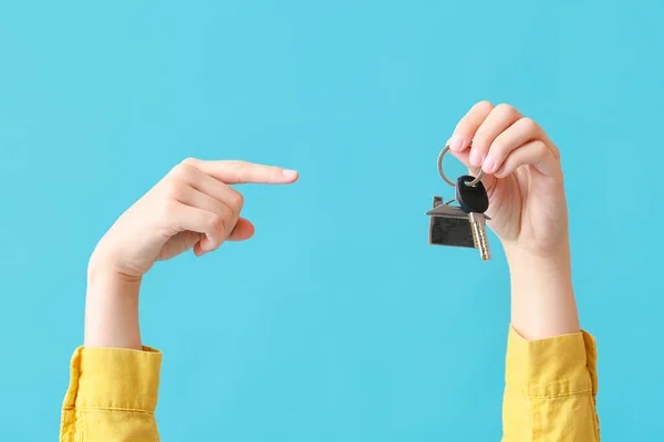 Young Woman Pointing Key House Blue Background — Stock Photo, Image