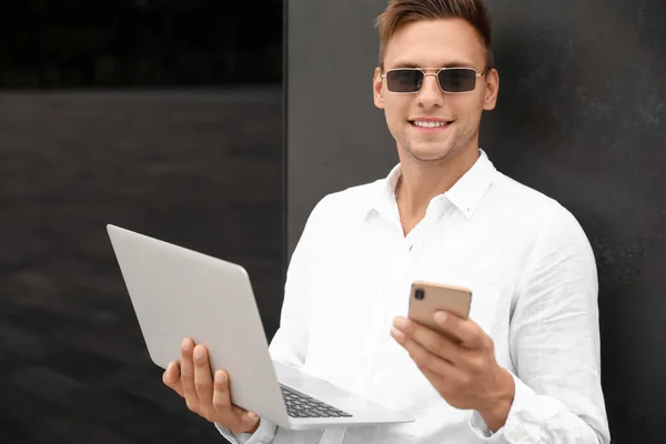 Young Man Sunglasses Laptop Using Mobile Phone Outdoors — Stock Photo, Image