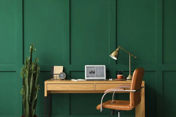 部屋の緑の壁の近くにノートパソコンと現代の職場 — ストック写真