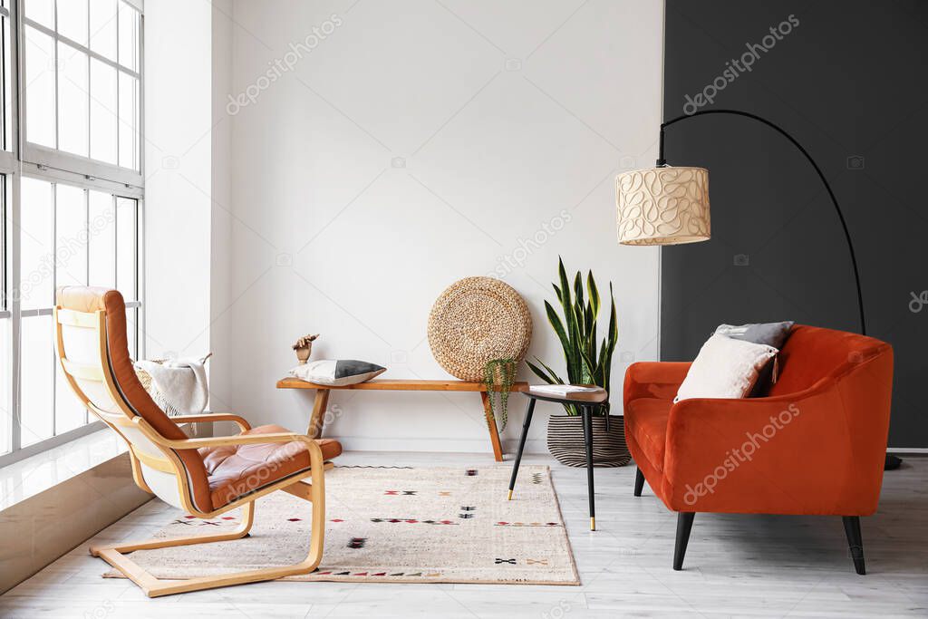 Modern bench with pouf, pillow and wooden hand in interior of light living room