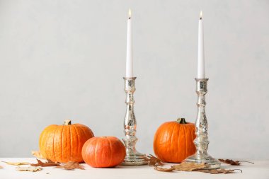 Işık zemininde şamdanlar ve balkabakları